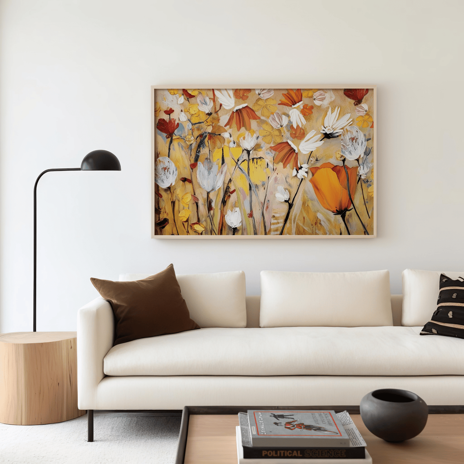 Orange and yellow floral wall art with white abstract flowers framed above a cream sofa in a modern living room with minimalist decor