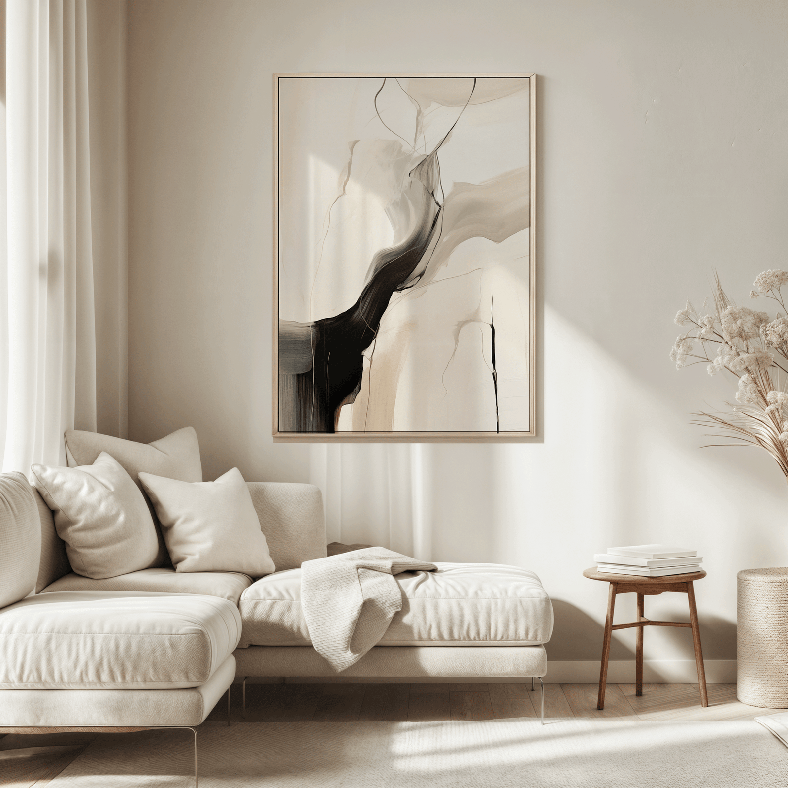 Modern living room with a neutral color scheme featuring a beige sofa, a large black, beige and grey abstract wall art print framed above the couch, and minimal decor.
