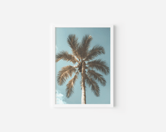 White-framed palm tree print with soft blue skies and white clouds