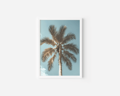 white-framed palm tree wall art print with soft blue skies and white clouds for coastal home decor