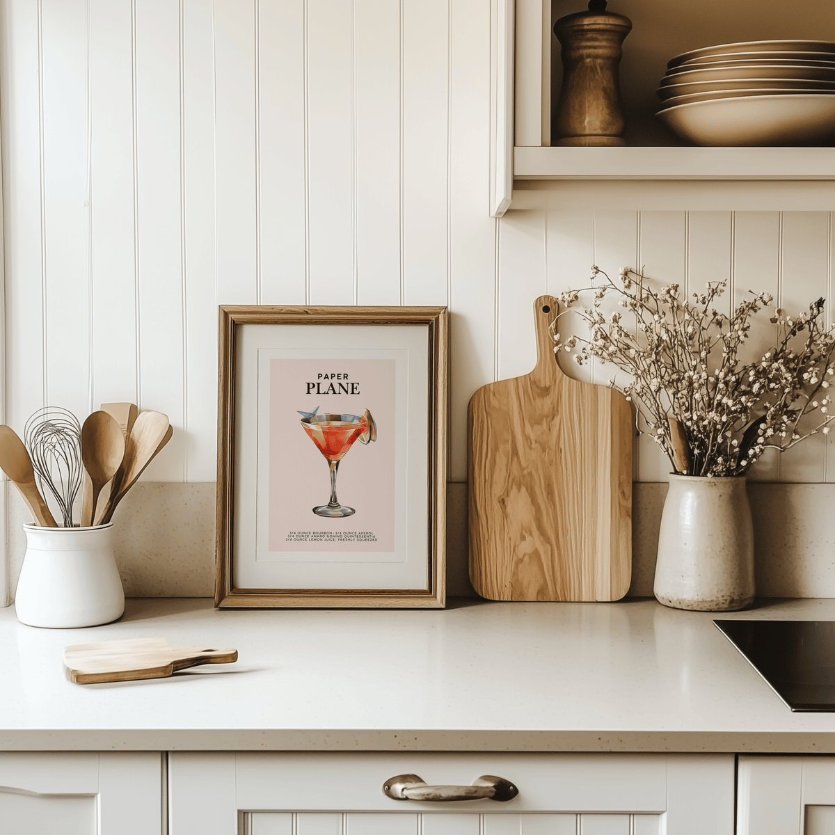 Paper Plane print in a natural frame on a white kitchen counter beside a cutting board
