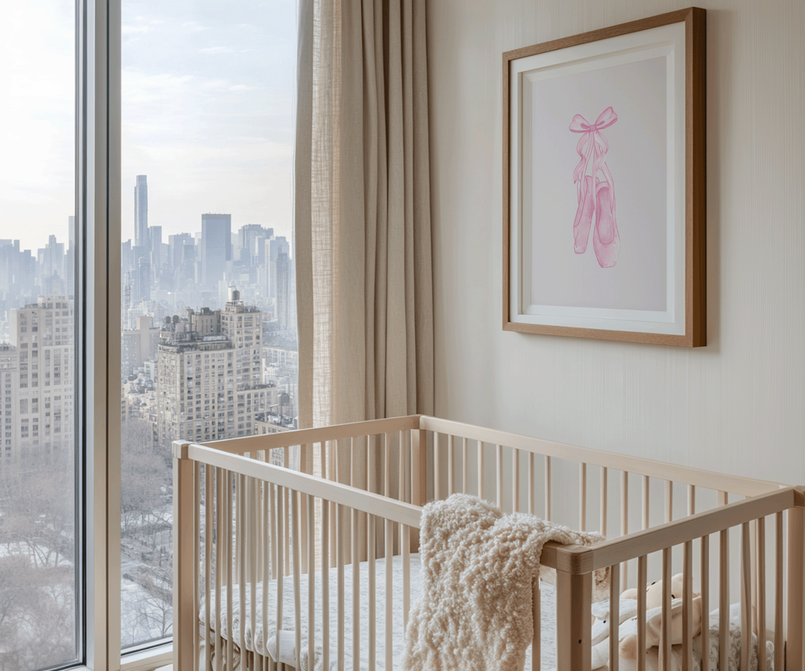 A wood-framed canvas wall art print with pink ballet slippers and pink bow on beige wall above a light wood crib in a modern nursery