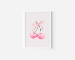 wall art featuring two pink cherries with a coquette bow on a white background with a white frame
