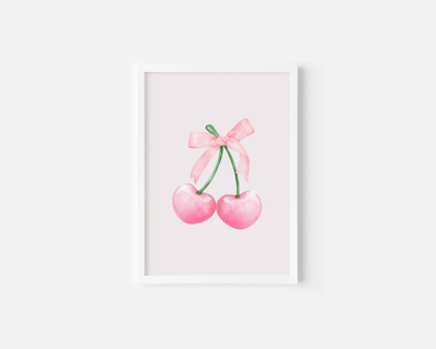 wall art featuring two pink cherries with a coquette bow on a white background with a white frame