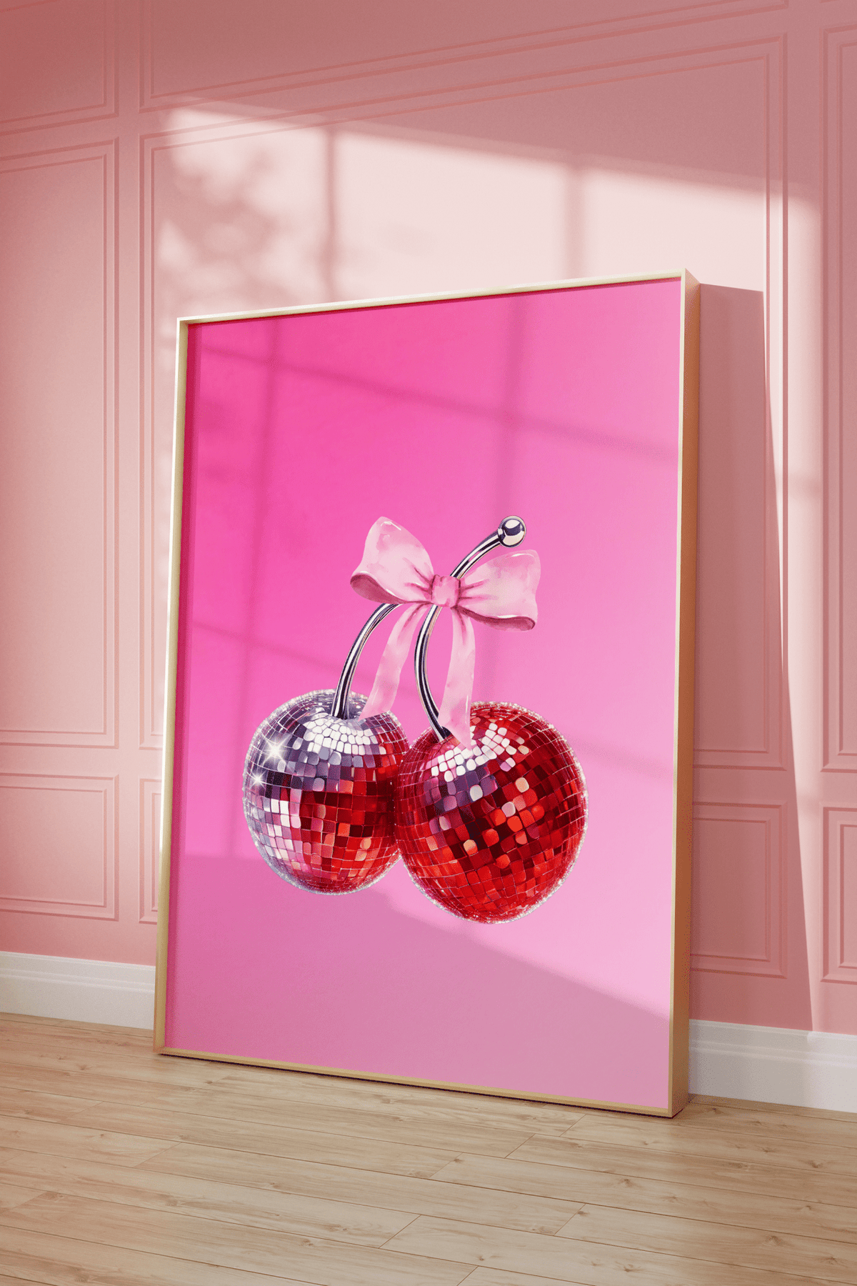 Pink cherry disco ball print in a natural frame leaning against a pink panelled wall