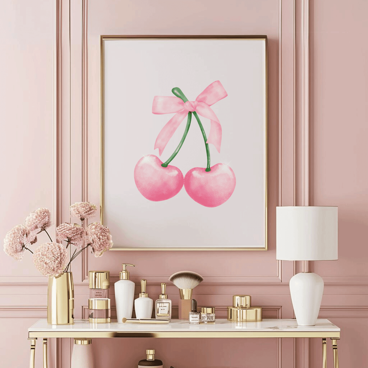 Framed wall art of pink cherries with a coquette bow on a pink wall above a vanity with decorative items.