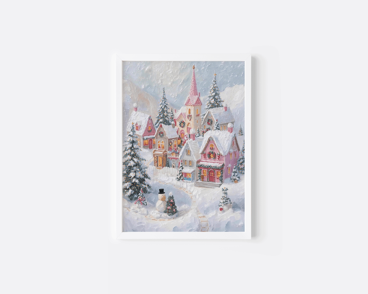 Pink Christmas village print in a white frame with snowy cottages, pine trees and pastel pink roofs