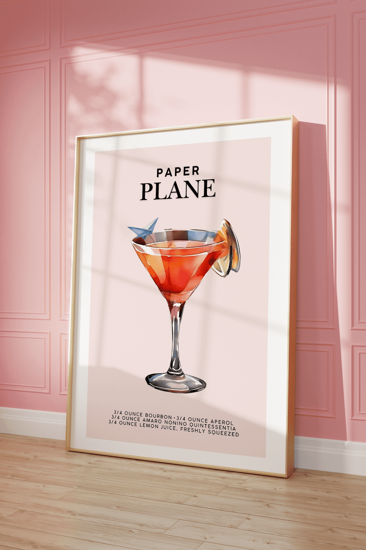 Pink cocktail print in a natural frame leaning against a pink panelled wall