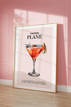 Pink cocktail print in a natural frame leaning against a pink panelled wall
