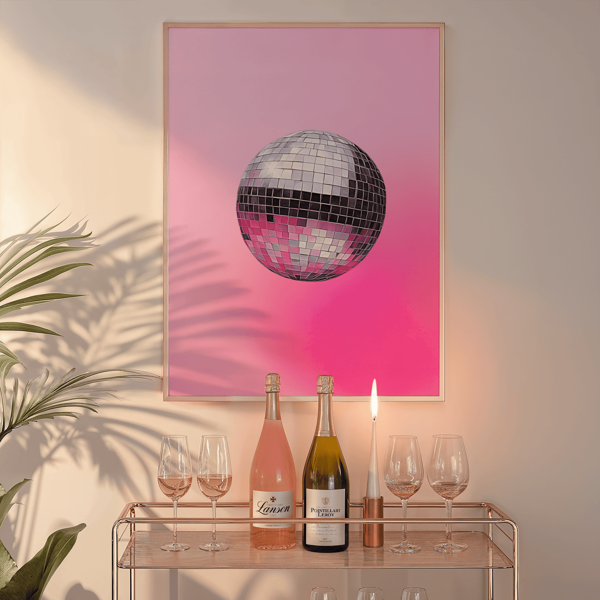 Pink disco ball print in a natural frame above a glass bar cart with wine bottles and a candle