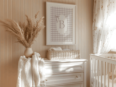 Personalized baby girl nursery wall art with gingham monogram letter B hanging above dresser and vase in a boho vintage nursery