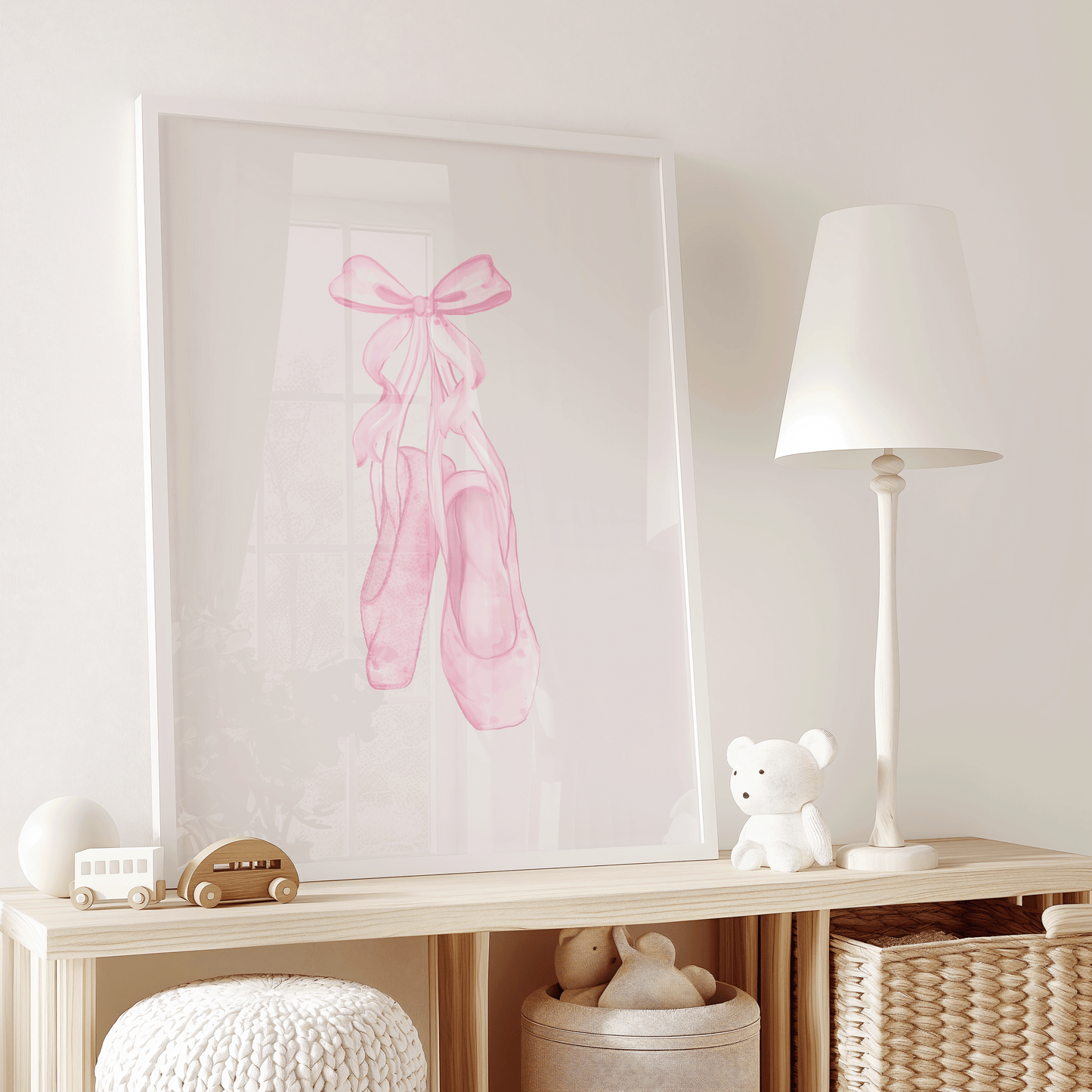 Framed artwork of pink ballet shoes on a shelf with toys and a lamp.
