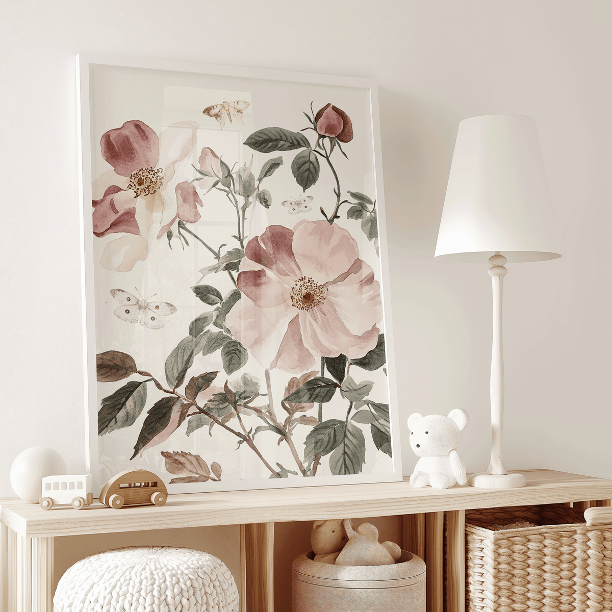 Pink rose floral print on a white dresser beside a lamp in a baby girl nursery