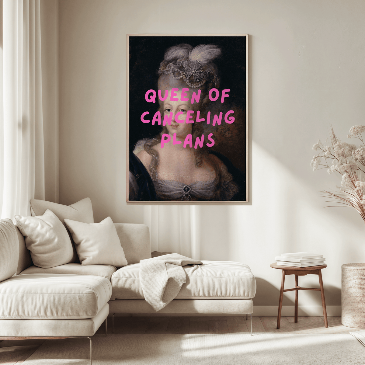 Queen of Canceling Plans print above a cream sofa in a neutral living room