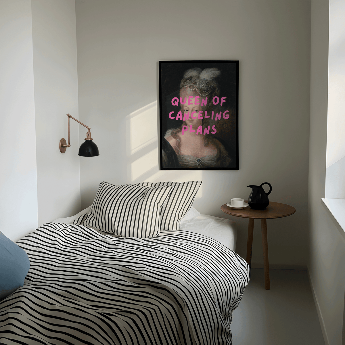 Queen of Canceling Plans print above a bed with black and white striped bedding