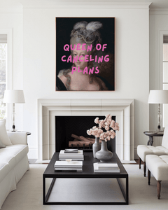 Queen of Canceling Plans print above a white fireplace in a bright living room with a black coffee table