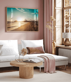 Natural framed Santa Monica wall art above a white sofa in a pink-toned living room