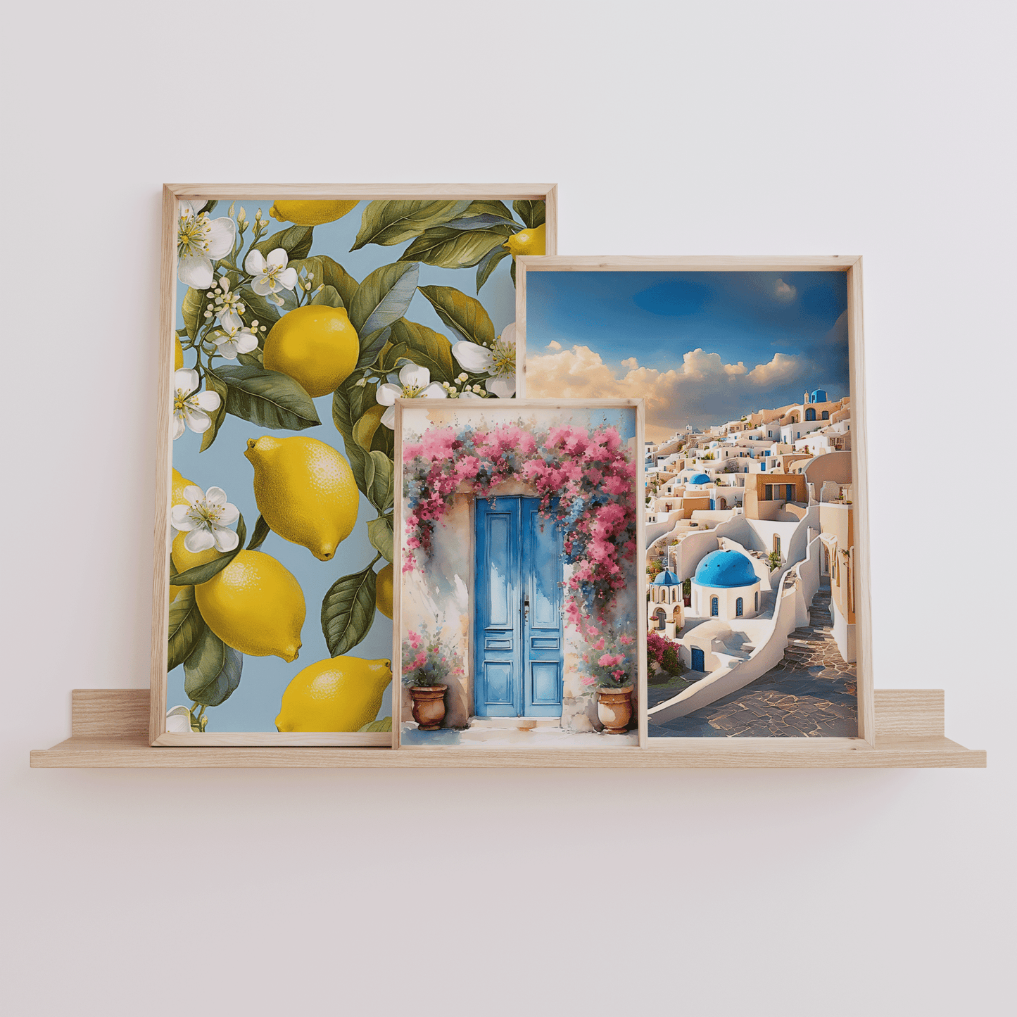 Mediterranean wall art set of 3 featuring lemon botanical print, Santorini coastal scene, and floral doorway artwork displayed on a wooden shelf