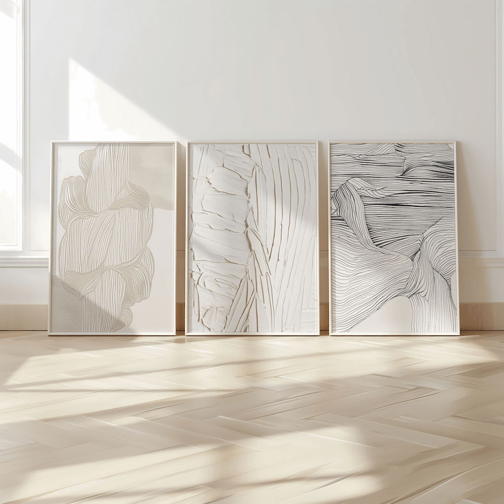 Three framed abstract wall art prints in black, white, beige tones with faux texture on a light wooden floor.