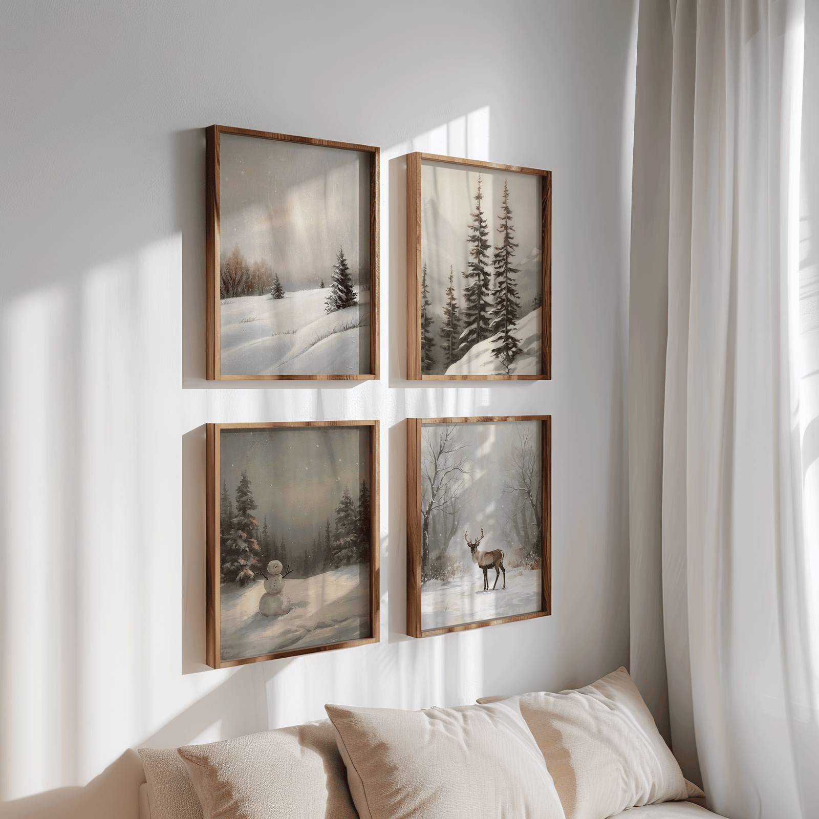 Four framed winter landscape prints arranged in a 2×2 grid on a white wall above a beige sofa, showing snowy hills, pine trees, a deer scene, and a snowman painting