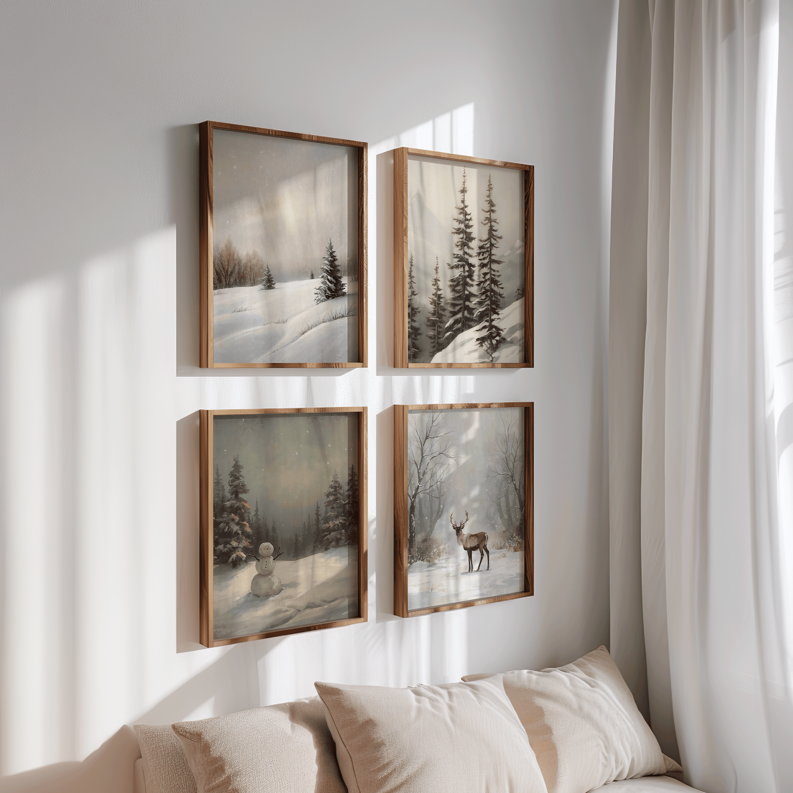 Four framed winter landscape prints arranged in a 2×2 grid on a white wall above a beige sofa, showing snowy hills, pine trees, a deer scene, and a snowman painting