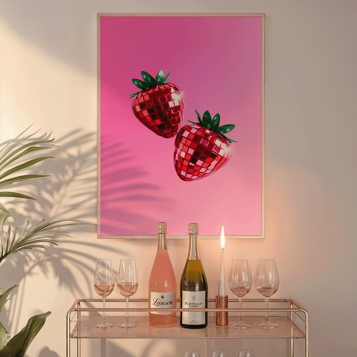 Strawberry disco ball print in a natural frame above a glass bar cart with wine bottles and a candle