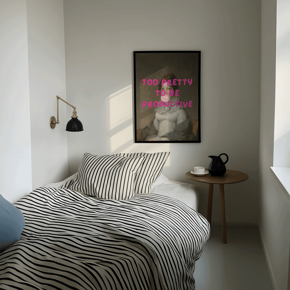 Modern bedroom with striped bedding, side table, and framed modern funny wall art print with 'too pretty to be productive' text.