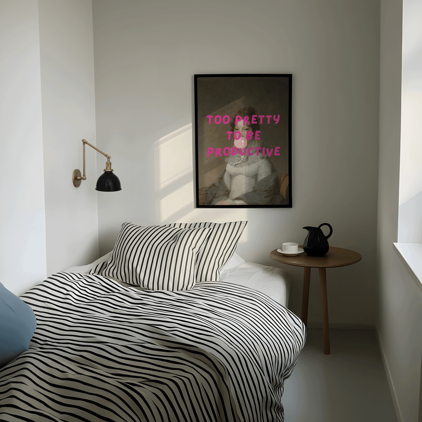 Modern bedroom with striped bedding, side table, and framed modern funny wall art print with 'too pretty to be productive' text.