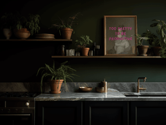Modern framed kitchen wall art print with funny typography with dark green walls and marble countertops.