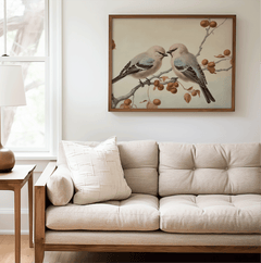 Walnut framed vintage bird wall art above a beige sofa in a living room