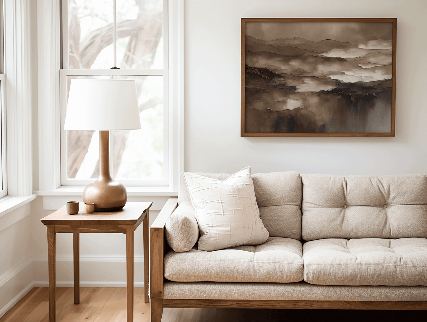 Vintage brown abstract wall art in a wood frame above a neutral sofa in a cozy living room