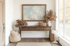 Horizontal framed cloud print above a wooden console table