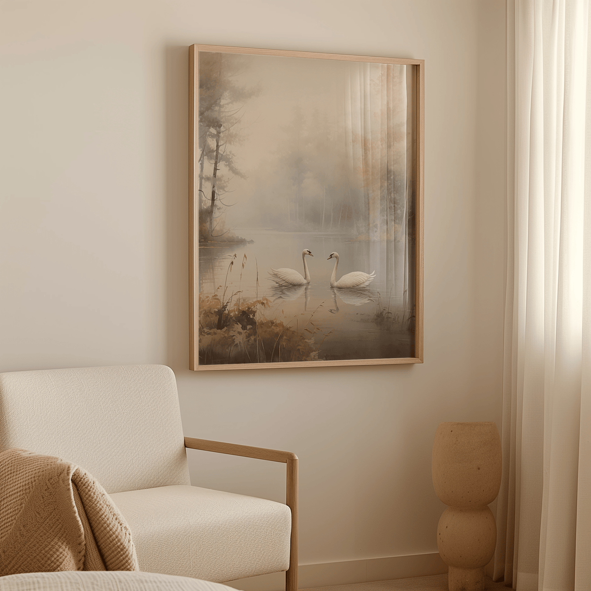 Wood-framed canvas wall art print of swans on a misty lake above a white armchair in a room.
