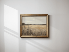 Framed vintage nature landscape wall art with golden fields and cloudy sky on minimalist wall