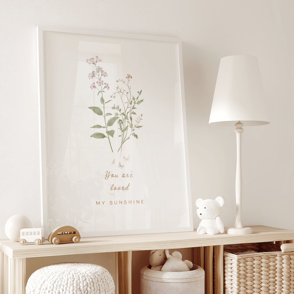 Neutral floral wall art in a white frame on a wooden open shelving unit for kids in a play room, featuring soft pastel botanicals, styled in a bright minimalist setting.