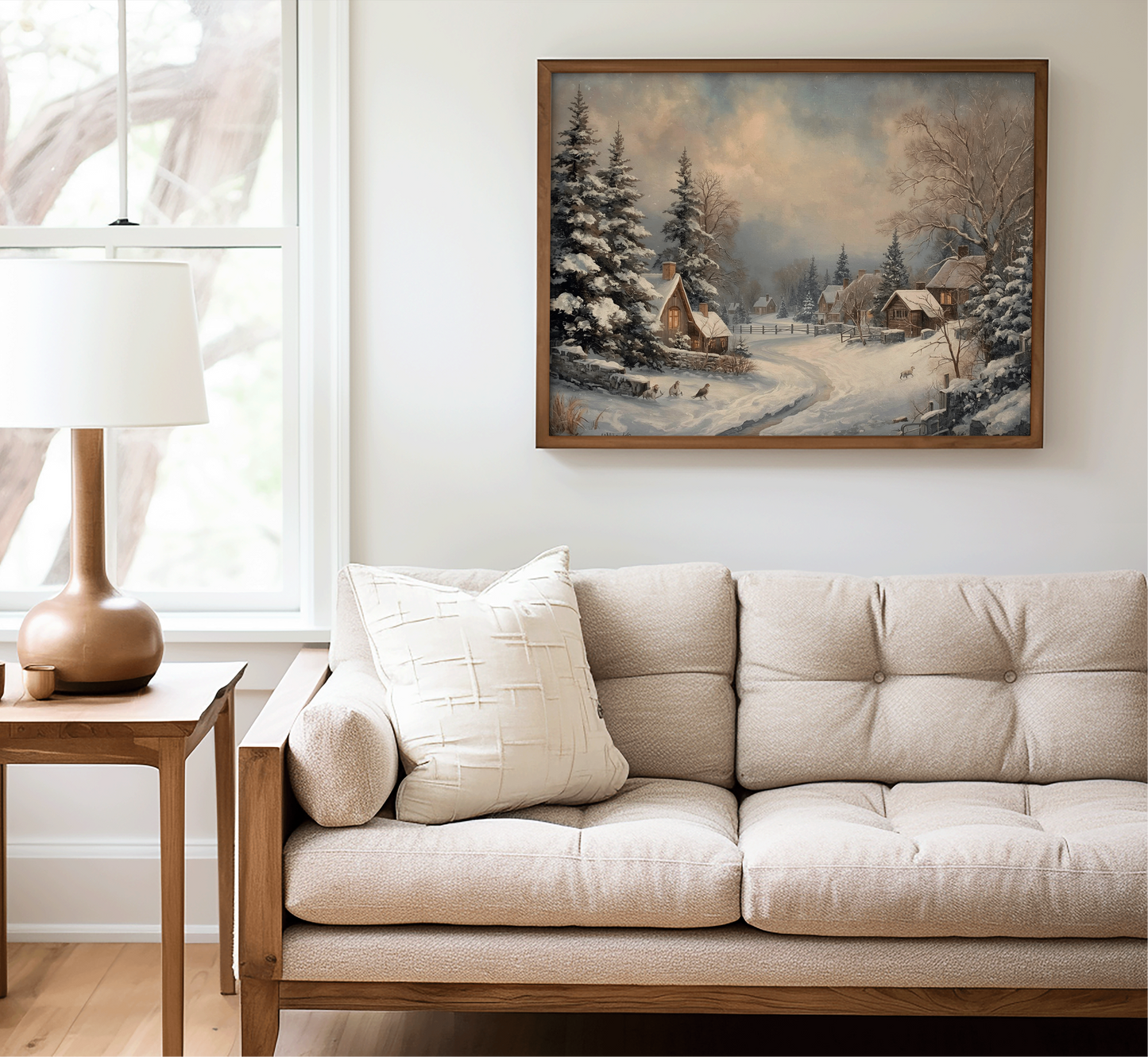 Neutral living room styling with cozy winter village landscape canvas wall art print in a oil painting style with a brown wooden frame, above beige tufted sofa.