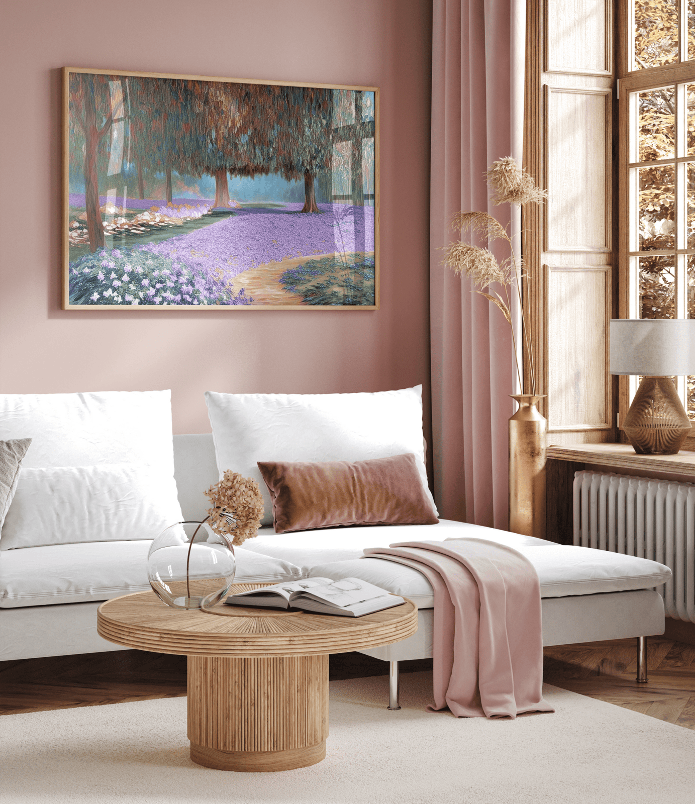 Purple lavender field landscape canvas wall art print featuring a peaceful countryside scene with trees and blooming purple flowers. Artwork is an impressionist style with faux-text and an oil-like painting. Placed above a white sectional sofa in a living room with blush pink walls and curtains, and wooden accents.