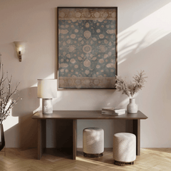 Walnut framed vintage tapestry wall art above a console table in a warm entryway