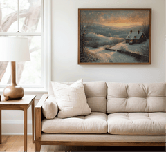 Vintage winter cottage print above a neutral sofa in a bright living room