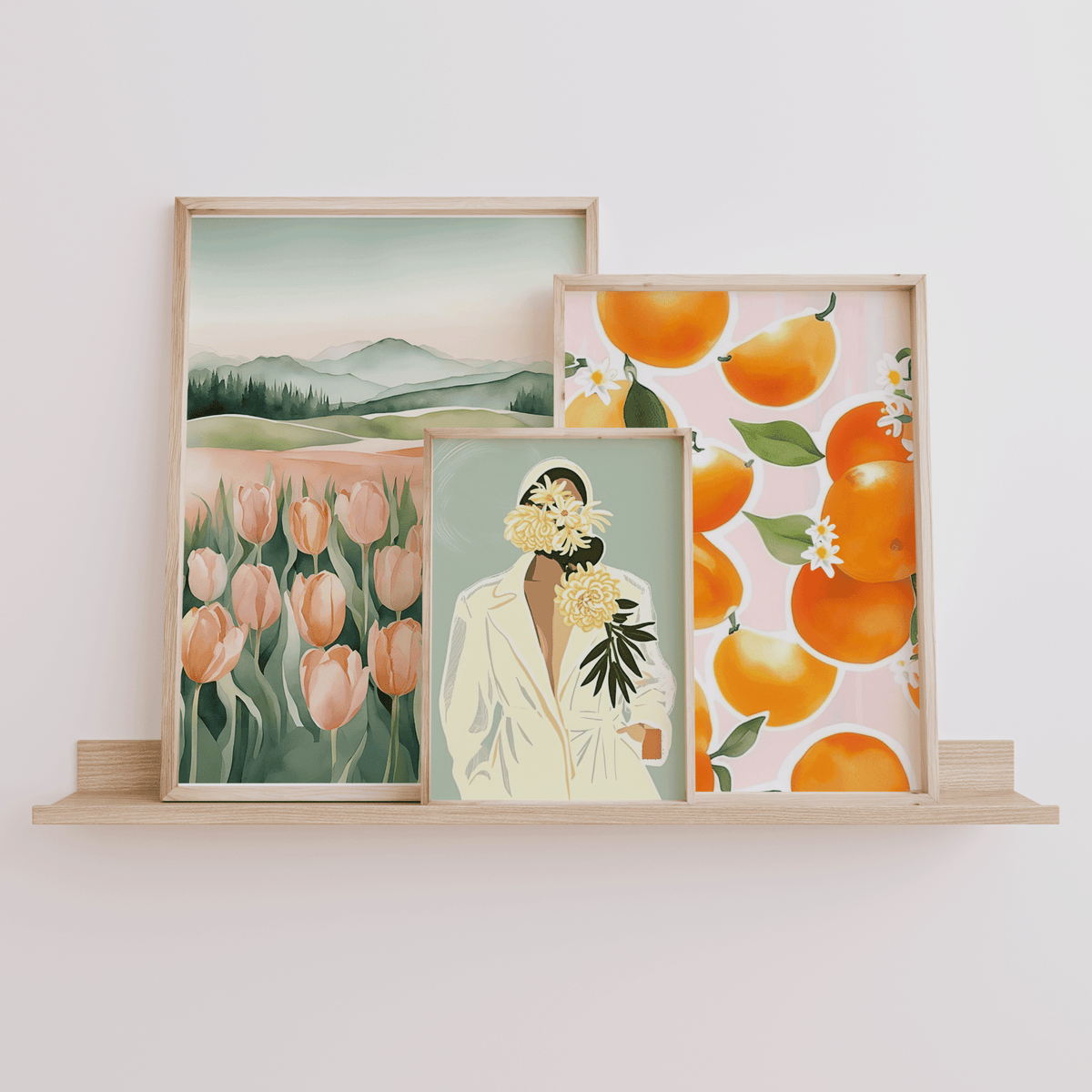 Watercolor tulip print leaning on a shelf beside a citrus print and a woman portrait print