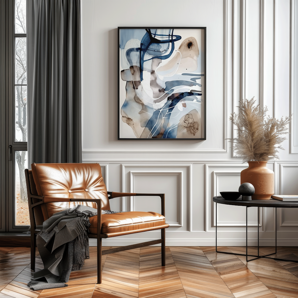 Abstract blue white and beige watercolor wall art in a black frame above a leather accent chair and side table