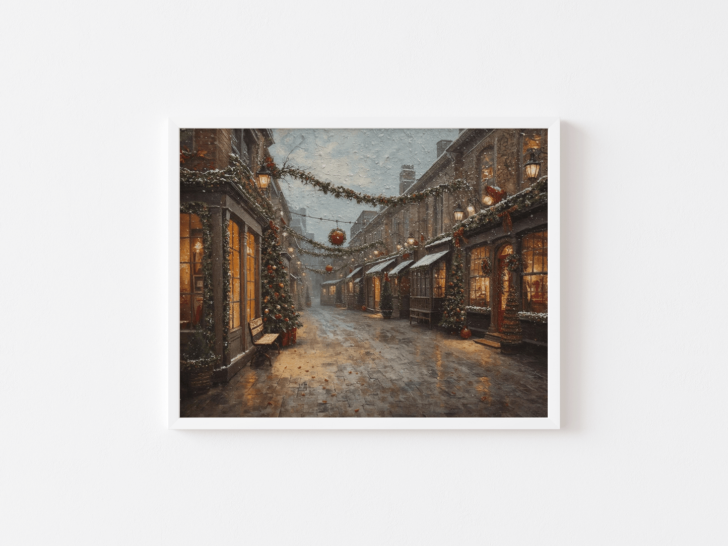 White-framed wall art of a charming snowy Christmas village street scene with warm lamplight, garlands, and textured oil painting brushstrokes on a plain white background.