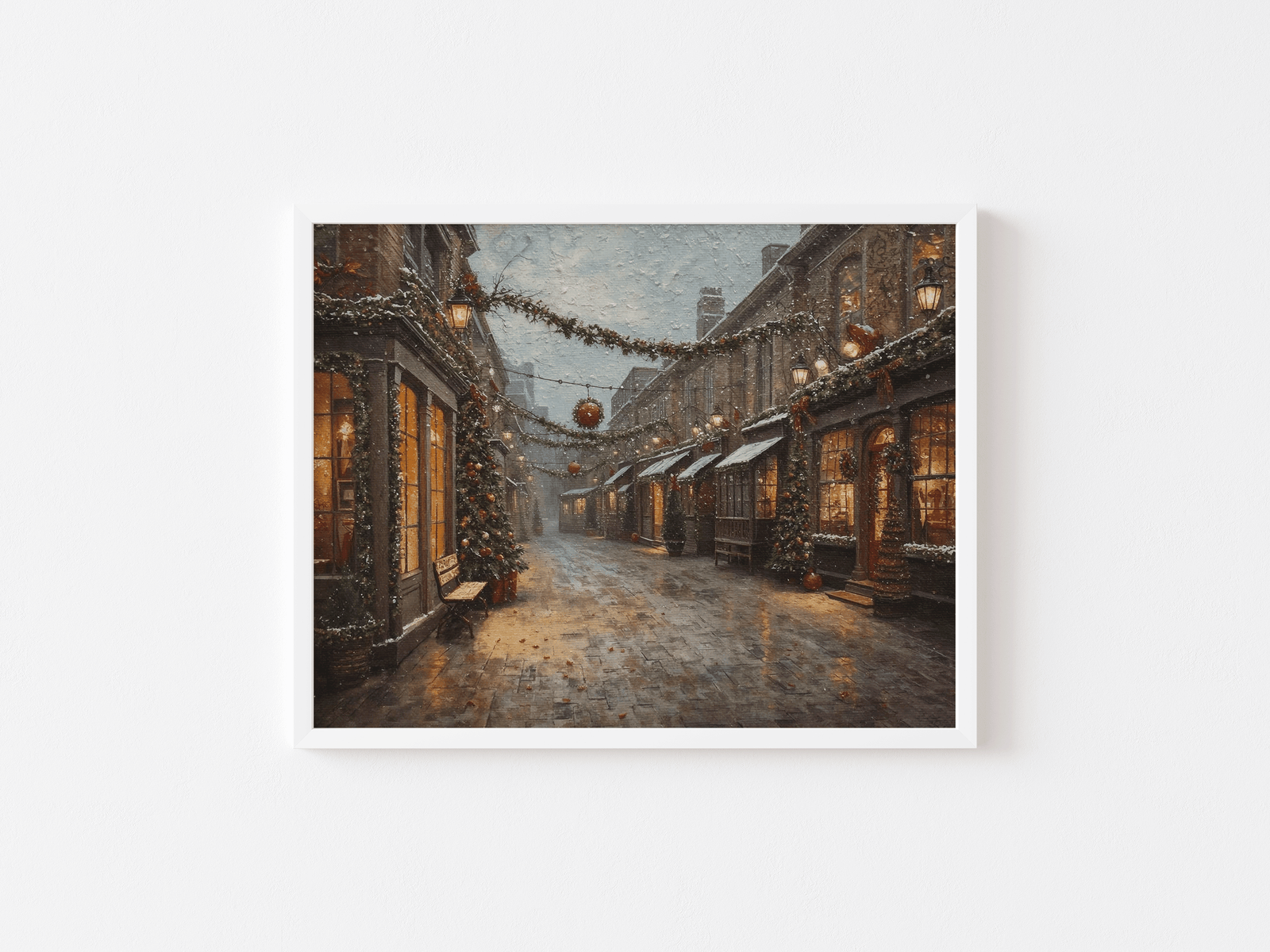 White-framed wall art of a charming snowy Christmas village street scene with warm lamplight, garlands, and textured oil painting brushstrokes on a plain white background.