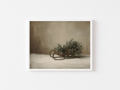 Vintage sleigh print in a white frame with winter greenery in soft neutral tones