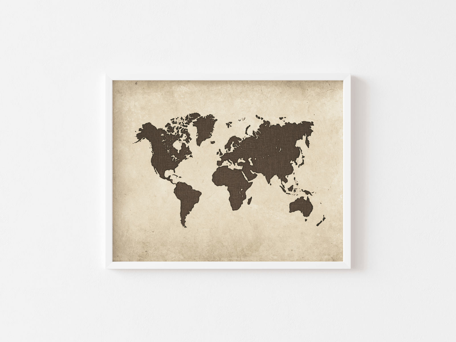 White-framed vintage world map wall art on a white wall