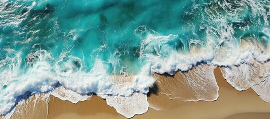 A background image captured from an overhead perspective, showcasing emerald ocean waves gently rolling onto the sandy beach in a wide panoramic view. Photorealistic illustration